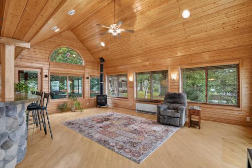 Great Room with walls of windows dressed in knotty pine walls & ceiling