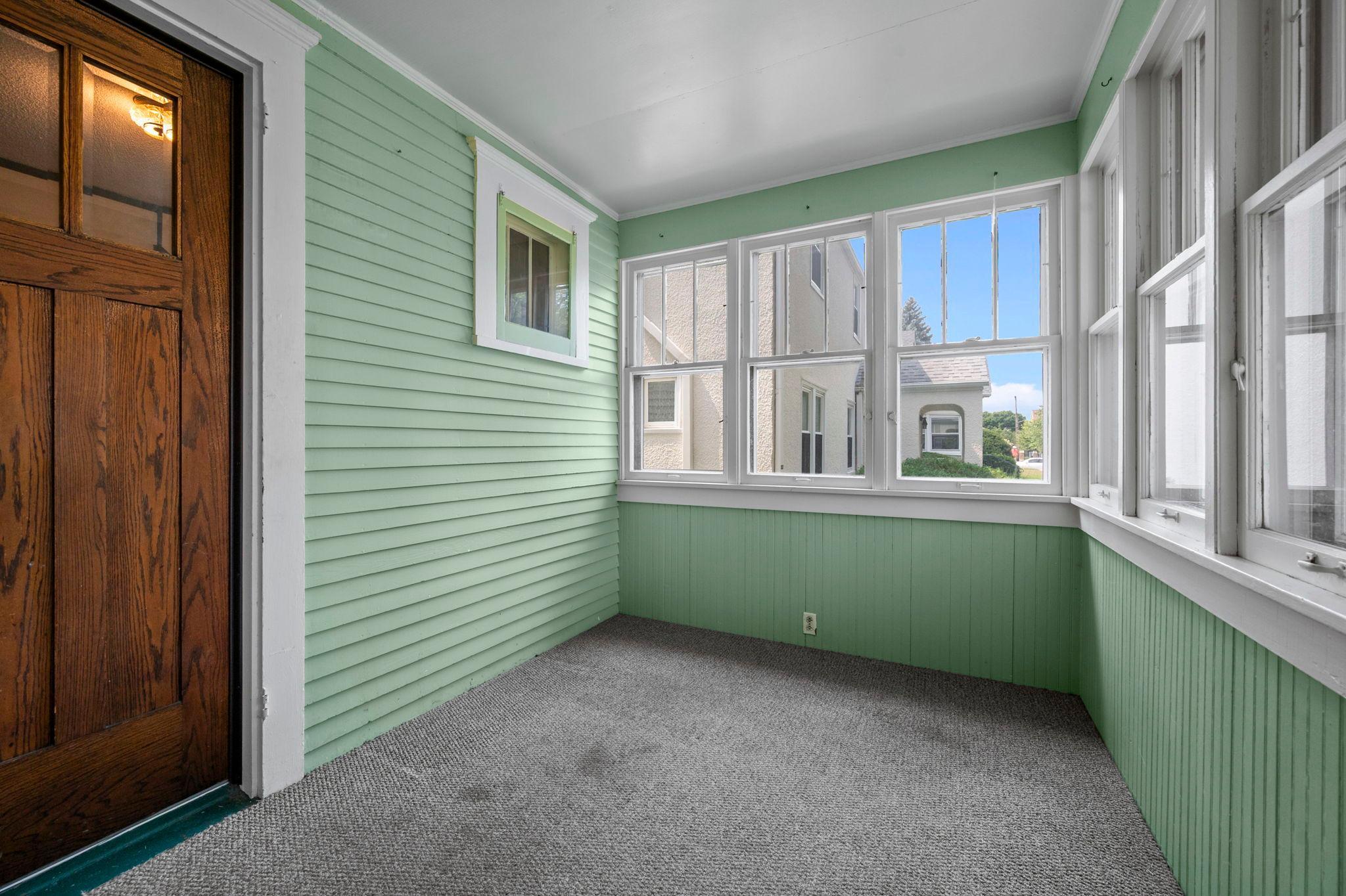 Bright enclosed front porch, perfect for morning coffee.