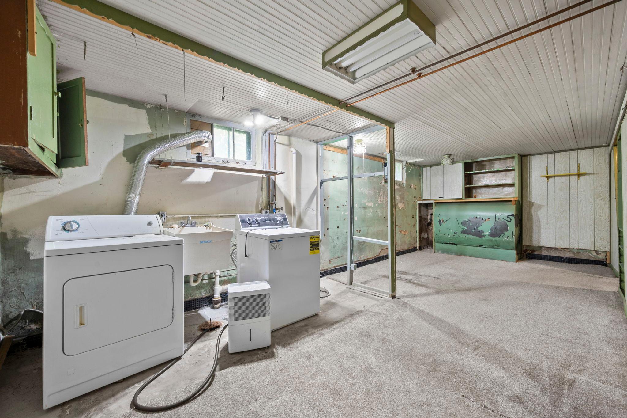 Spacious drain-tiled lower level with built-in shelving — enclose the laundry area and this could become a great family room or rec space.