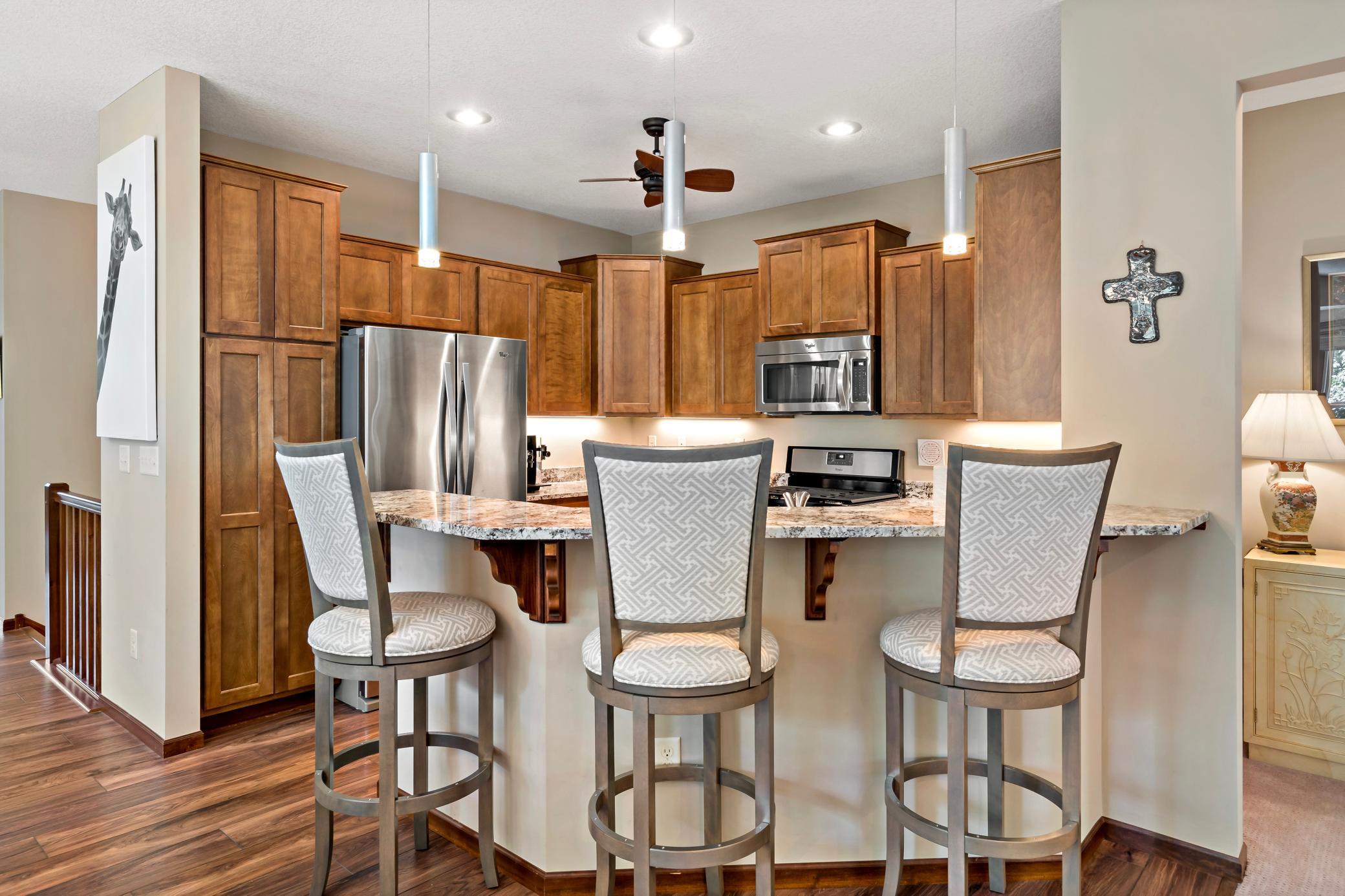 The kitchen boasts a convenient and beautiful granite breakfast bar with updated pendant lighting. Custom made stools are available for purchase.