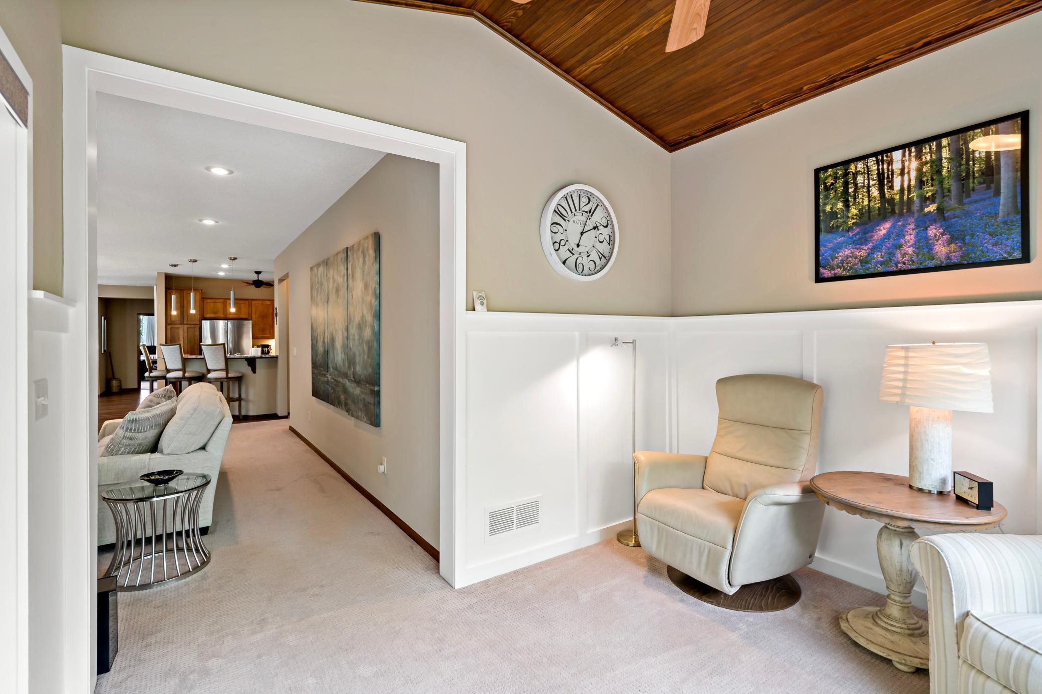 The white wainscoting elevates the design features of the space balancing it against the stunning ceiling and wooded views.