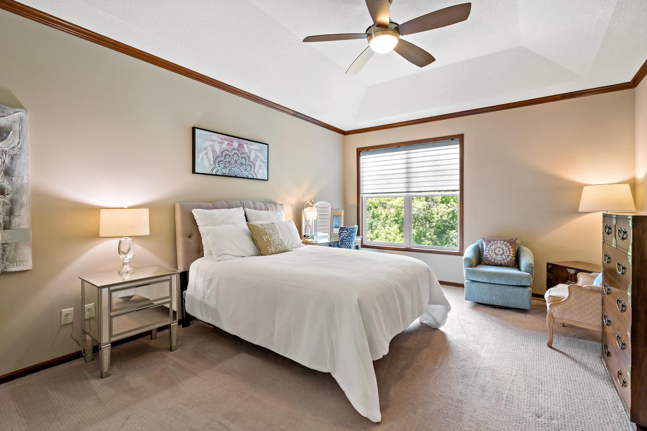 The main level primary bedroom offers a tray vaulted ceiling with ceiling fan, views of the private back yard, and a private bathroom ensuite with dual sinks, a jetted tub, separate shower, and massive walk in closet.