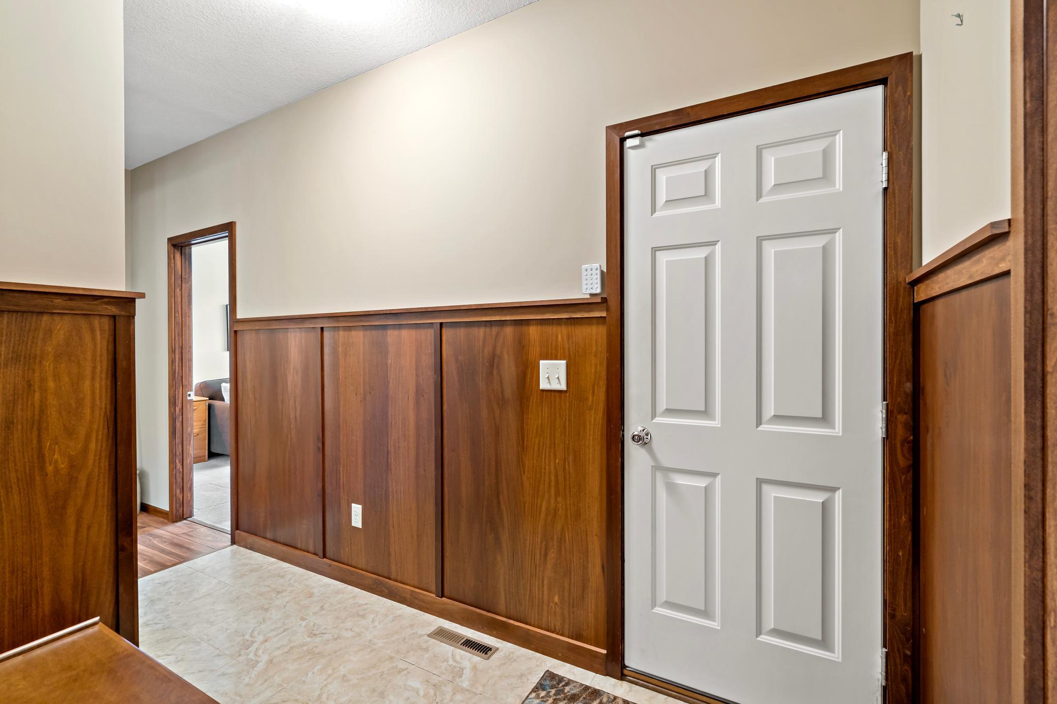 The hallway entrance from the garage is sure to impress with its wainscoting and size.