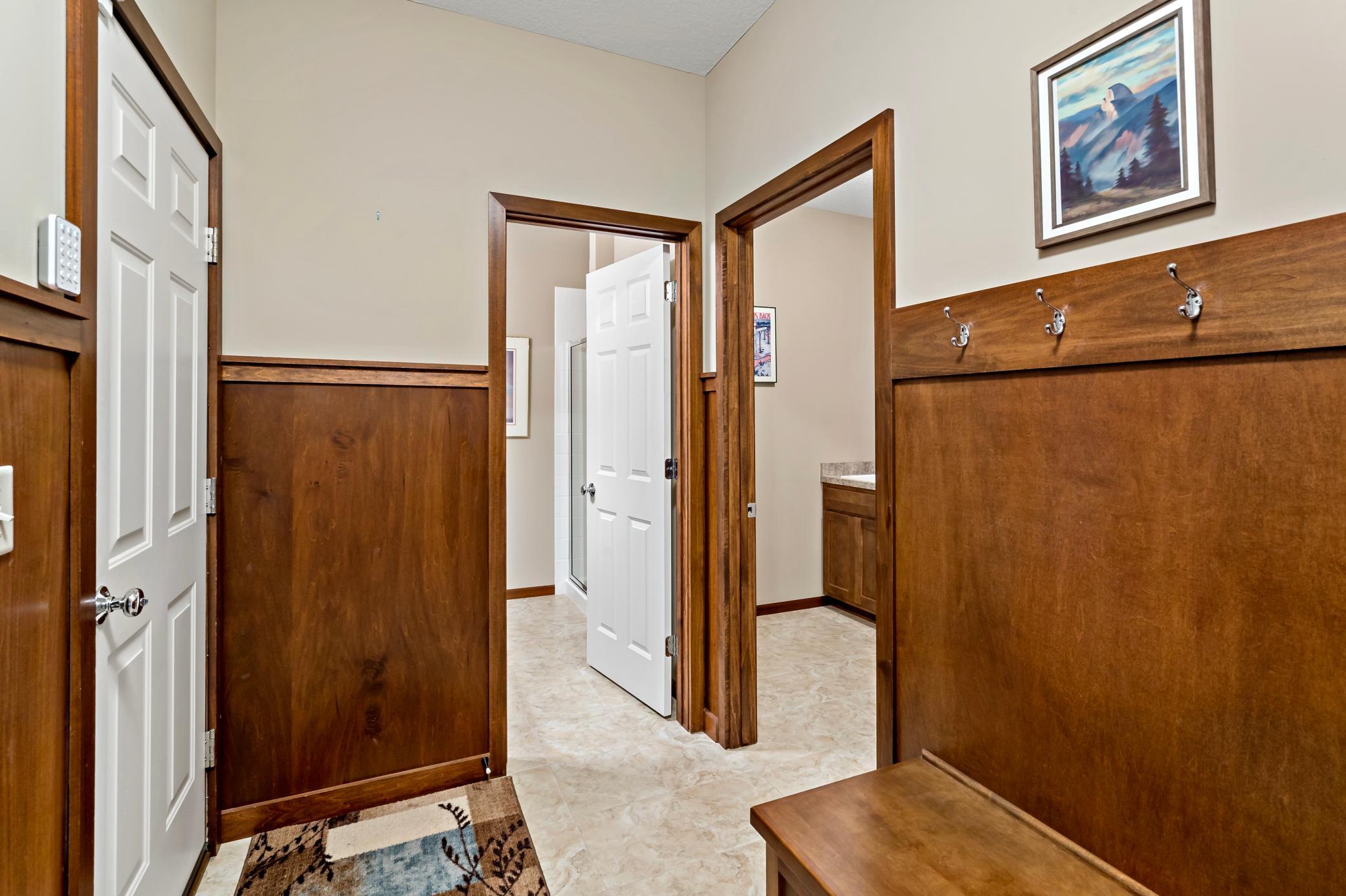 Entering from the two stall garage the "back" foyer offers a built in bench and coat hooks for convenience, access to a 3/4 bath and laundry room, and a coat closet.