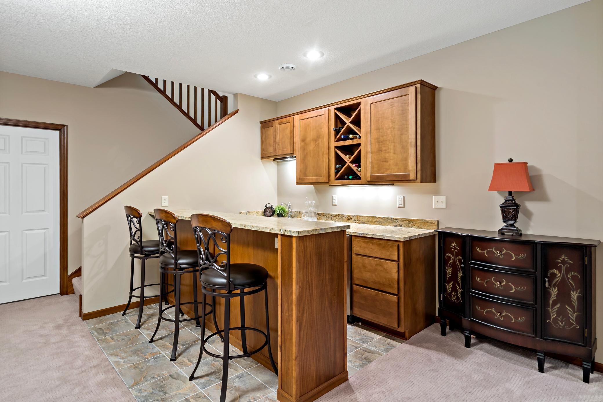 Upon descending the wide staircase, the exquisite details continue. The wet bar offers storage, a beverage cooler and the perfect centerpiece for entertaining.