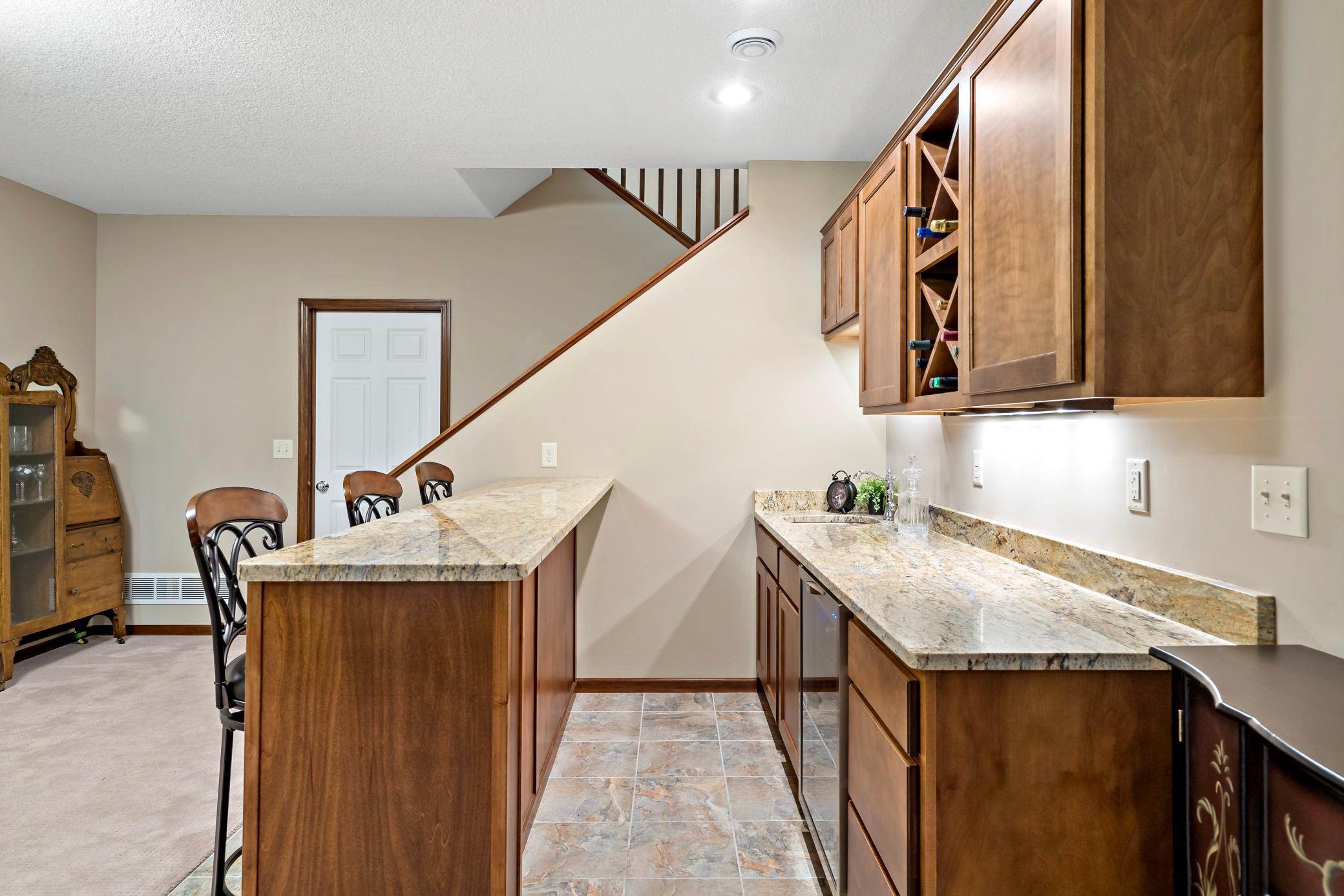 A sneak peak behind the bar showcasing the beverage fridge, sink, and abundant storage.