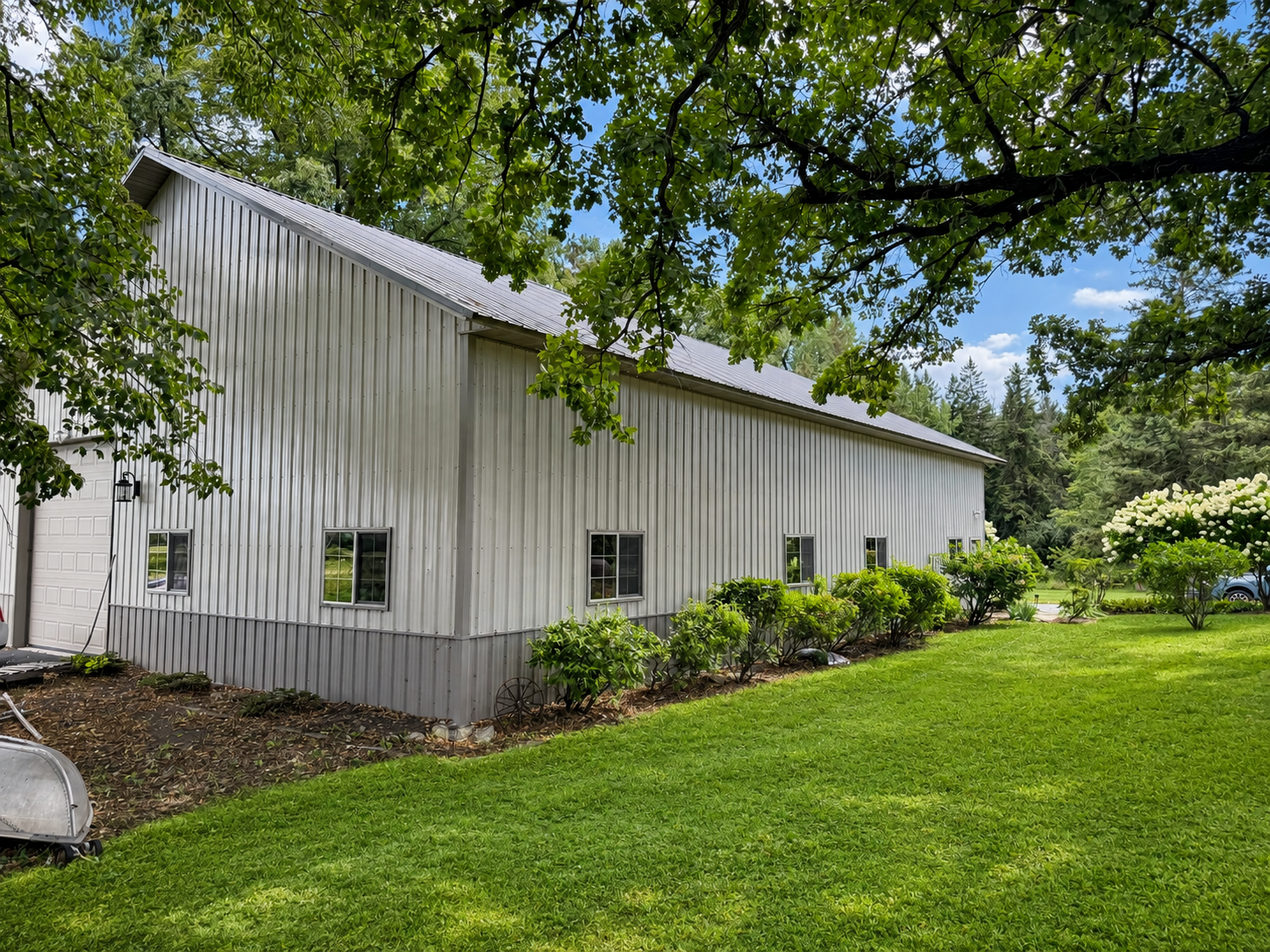 outbuilding rear view. There is an asphalt pad off the rear door. Building has two 16'X12" garage doors. One in the fornt of the main driveway and one in back.
