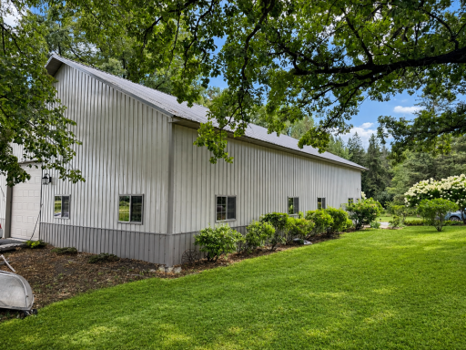 outbuilding rear view. There is an asphalt pad off the rear door. Building has two 16'X12" garage doors. One in the fornt of the main driveway and one in back.