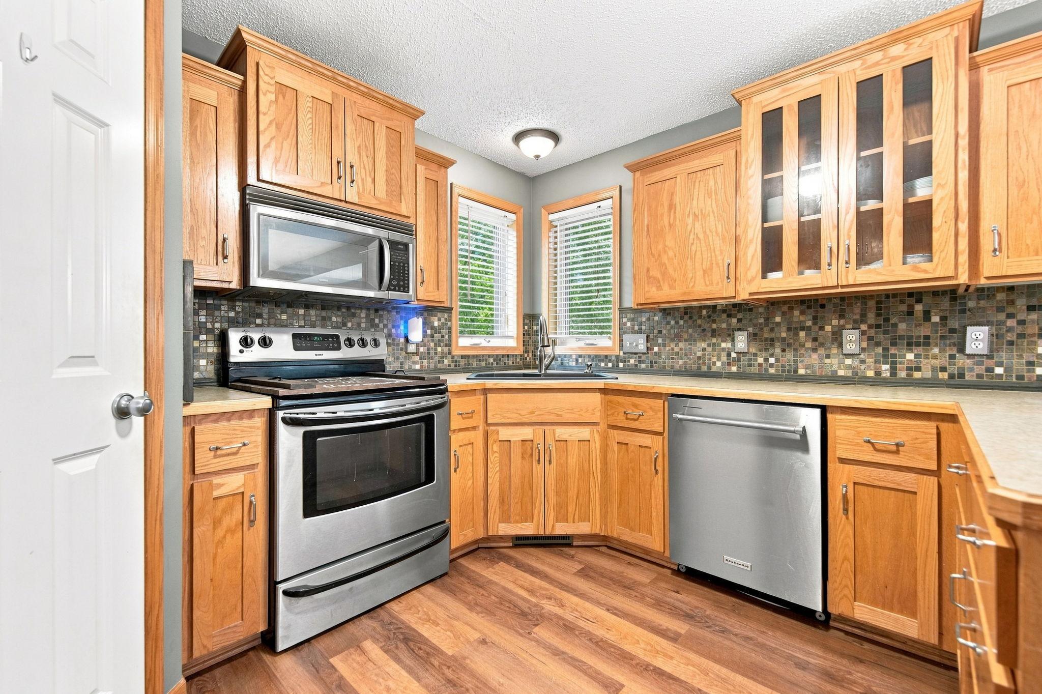 Features features stainless appliances, tile backsplash, and corner pantry!