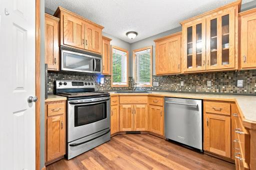 Kitchen features stainless appliances, tile backsplash, and corner pantry!
