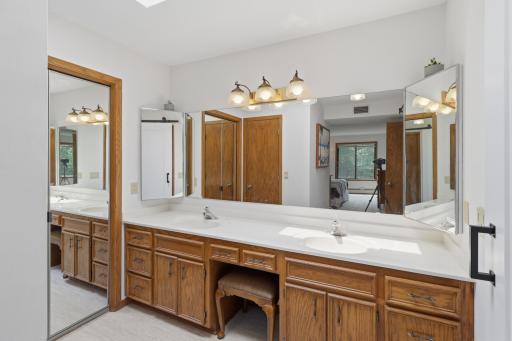 Large primary bathroom with new flooring, a skylight and a double vanity.