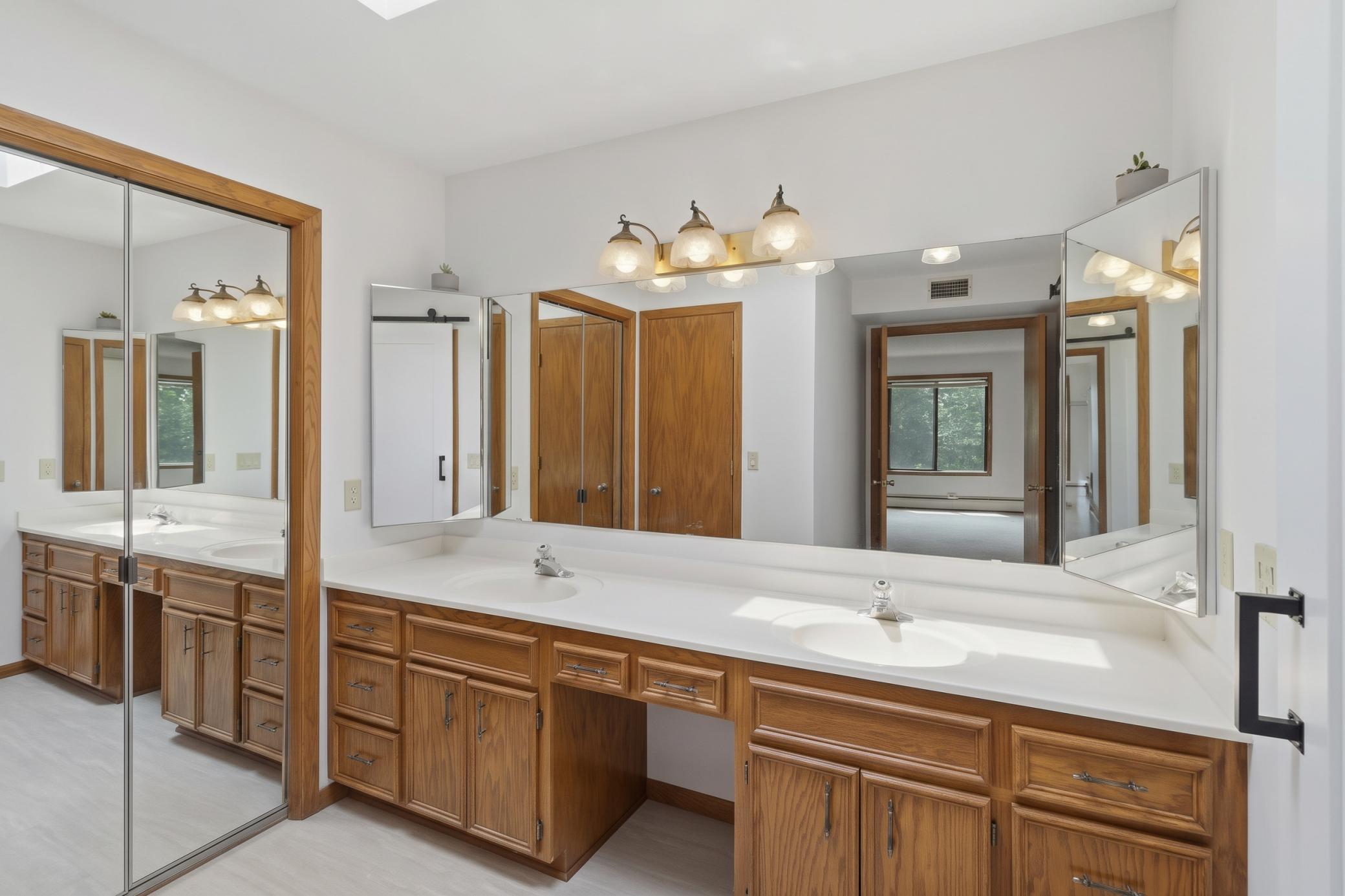 Large primary bathroom with new flooring, a skylight and a double vanity. .jpg