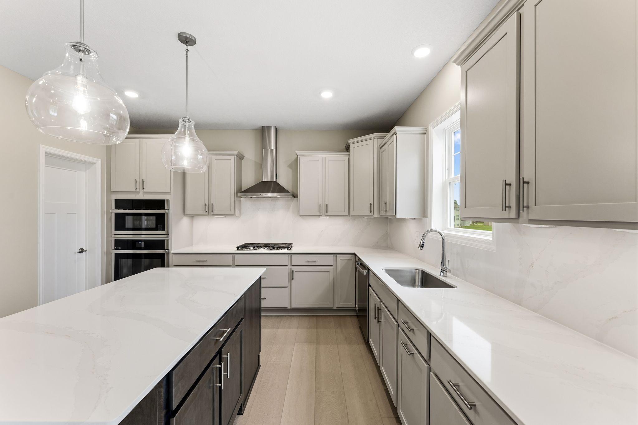 (All the following photos are of a similar home, actual finishes may vary.) This stylish kitchen showcases a large center island, Shaker-style cabinetry, and brand-new stainless-steel appliances.
