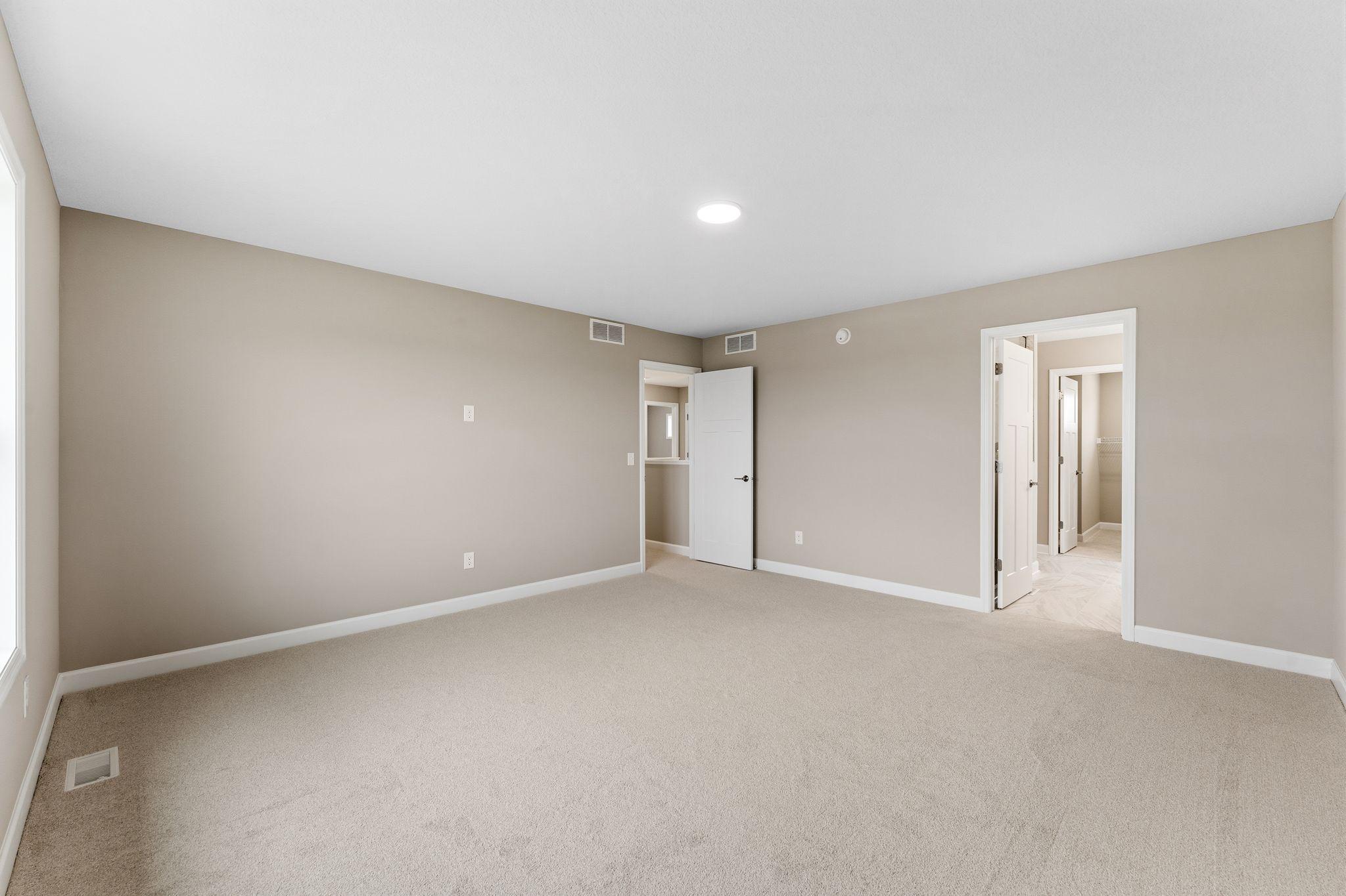 This spacious bedroom is complete with ample room for a king-sized bed