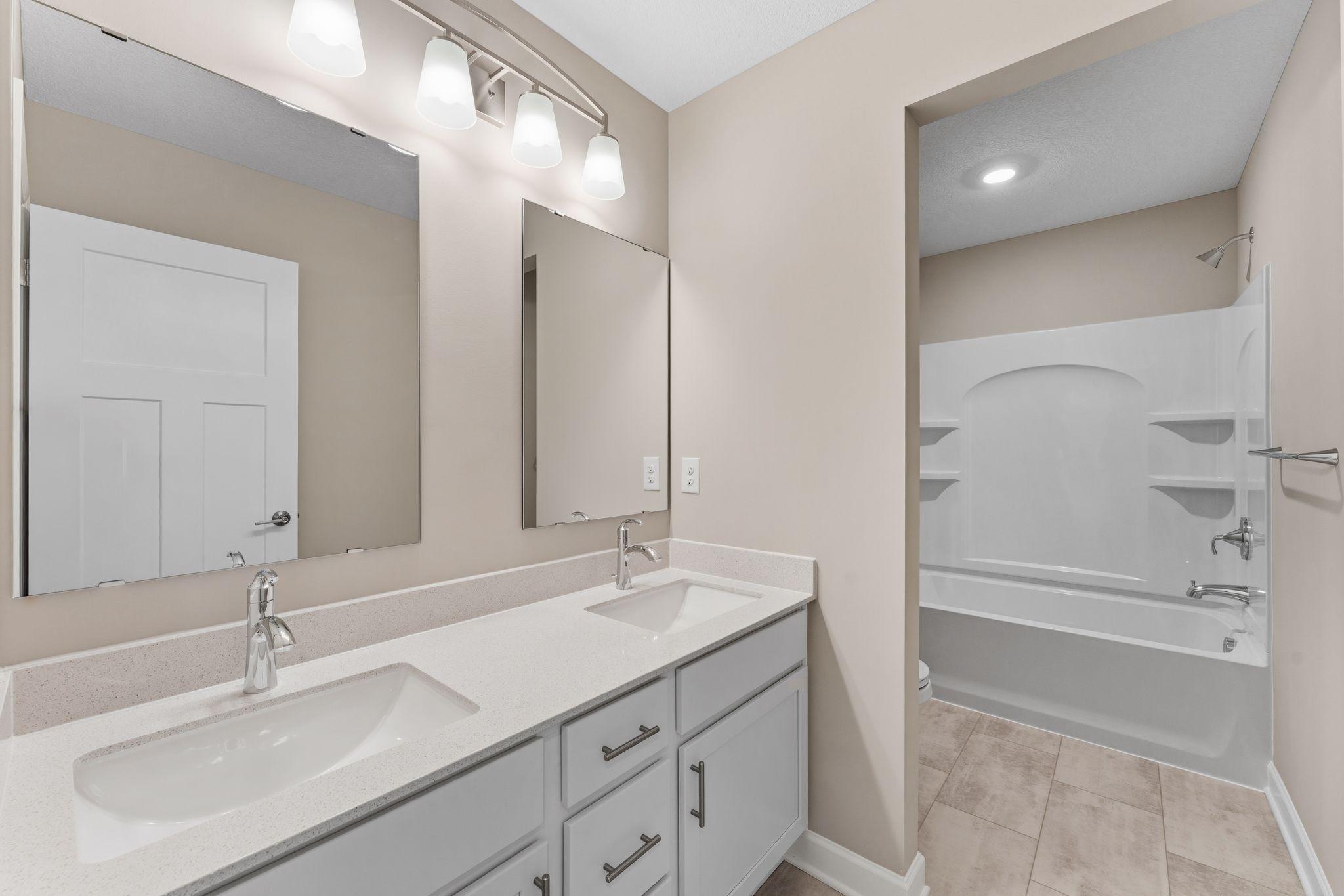 This full bathroom is conveniently located on the second floor and showcases dual sinks and a shower-tub combination.
