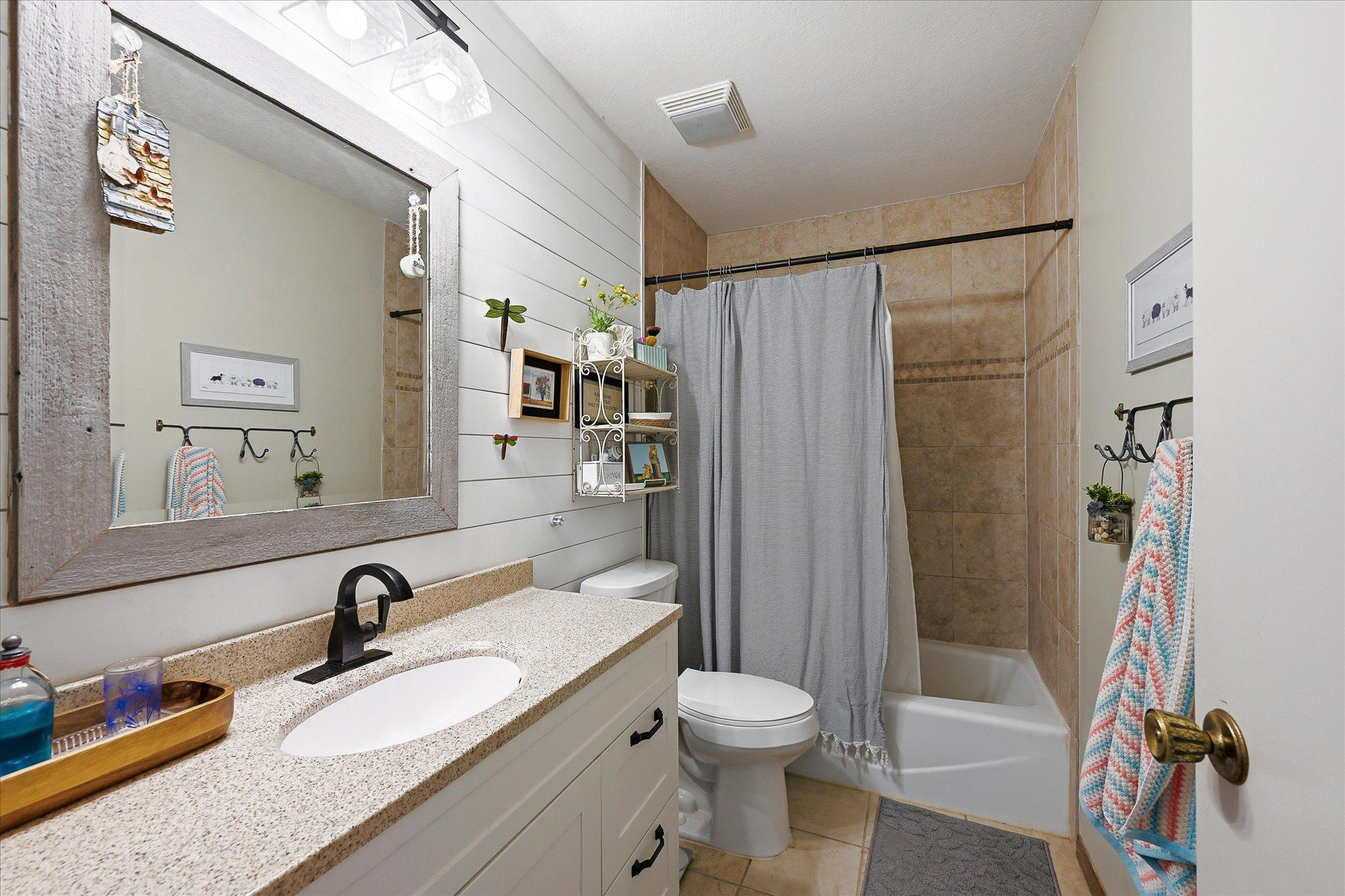 Remodeled bath with nice vanity space and tiled shower
