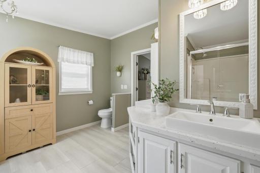 Enjoy beautiful basin sinks with dual vanity.There is space for storage and the toilet is hidden behind a half wall.