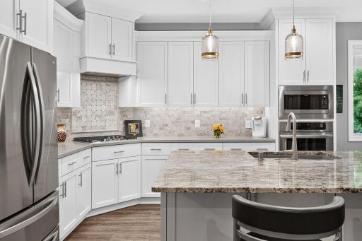 Amazing kitchen area with gas cooktop, quartz counters and neutral backsplash...