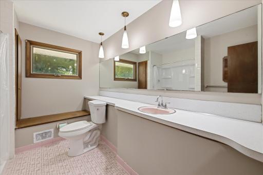 The full upper-level bathroom features a spacious vanity, oversized mirror, updated lighting, and plenty of room to comfortably serve the home's bedrooms.