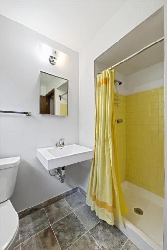 A convenient three-quarter bathroom serves the main level, offering updated fixtures and a walk-in shower for guests or anyone enjoying the nearby family room and den.