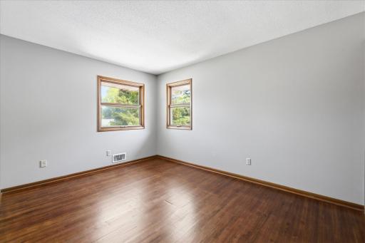 Another bright and inviting bedroom offers refinished hardwood floors, large windows, and flexible space for family, guests, or a comfortable home office.