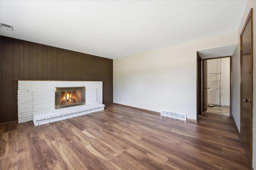Rich wood accents and the inviting fireplace add warmth and character to this comfortable living space, while the open layout makes it ideal for everyday living or entertaining guests.