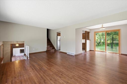 Head up a few steps to the bright main living area, where refinished hardwood floors, large windows, and an open layout create a welcoming space that connects seamlessly to the dining room.