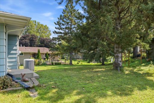 The spacious backyard is framed by mature trees that provide shade, privacy, and a tranquil setting throughout the seasons.