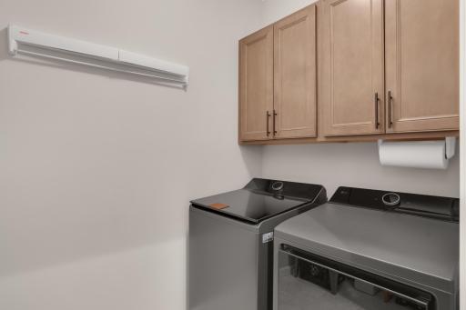 Main floor laundry room with cabinets for storage.