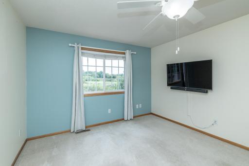 Primary bedroom with neutral color carpet
