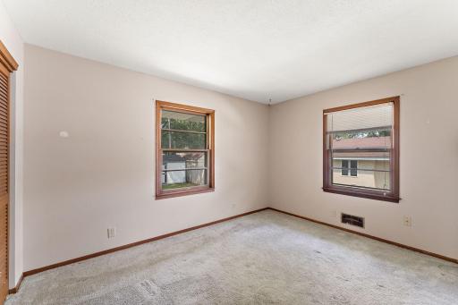 The primary bedroom has a view of the backyard and has carpet.