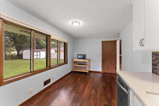 The kitchen/dining room with large windows offering a view of the patio and backyard.
