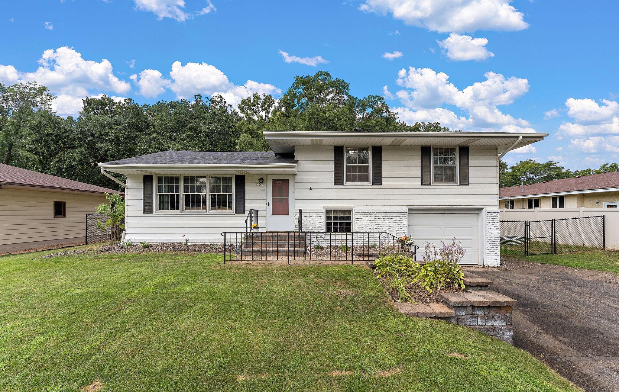 The front of the home has a paved driveway, a one car tuck-under garage and a well maintained yard to the curb.