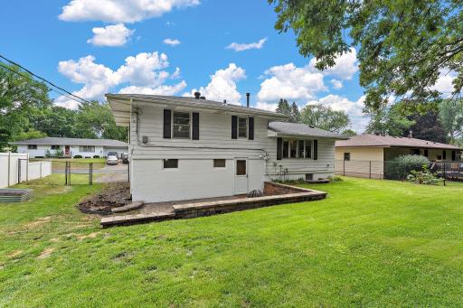 The backyard is fully enclosed with a chain link fence, a paved low patio for entertaining and relaxing as well as plenty of green space for flower beds or yard games.