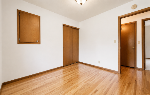 The third bedroom with the door open to the hallway and a view of the primary bedroom visible beyond.