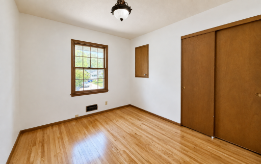The third bedroom features a window view of the street and a closet to the right.