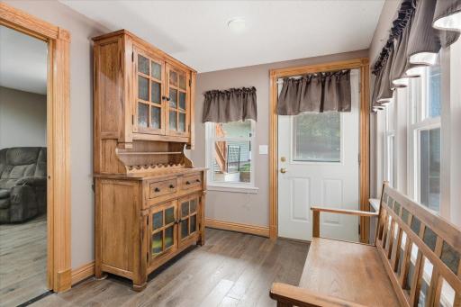 Functional mudroom offers the perfect transition from the backyard with durable luxury vinyl plank flooring, abundant natural light, rich oak custom trim, and plenty of space for coats, shoes, and everyday essentials.