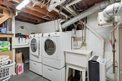 Lower-level laundry room includes a utility sink, and additional storage options. For added convenience, washer and dryer hookups are already available in the spacious primary walk-in closet.
