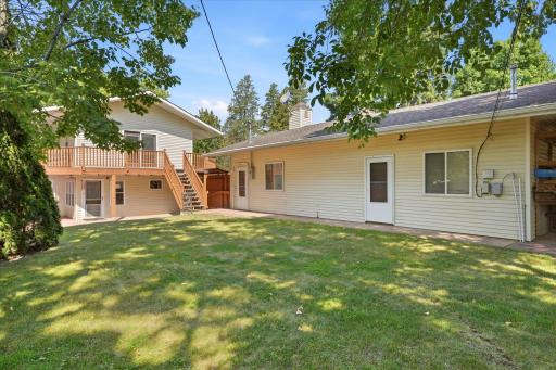 Meticulously maintained, fully fenced backyard offers exceptional privacy with a wraparound deck, expansive patio, and attractive privacy fencing, creating a peaceful outdoor retreat perfect for relaxing or entertaining.