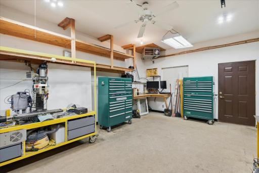 Large 21' x 15' heated workshop offers an impressive amount of functional workspace with built-in shelving.