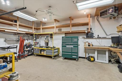 Dedicated 21' x 15' heated workshop is a dream for hobbyists, craftsmen, or small business owners, offering extensive built-in shelving, durable work surfaces, overhead storage, excellent lighting, and direct access to the garage.