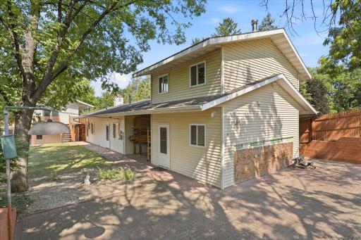 Two-story studio showcasing the covered carport that connects the structure to the garage. The thoughtfully designed layout creates a seamless transition between the workshop, office, studio, and outdoor living spaces.