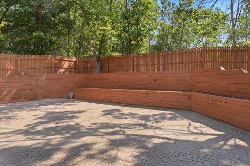 Beautifully designed courtyard offers low-maintenance paver hardscaping, custom tiered retaining walls with planting beds, and complete privacy thanks to the fully fenced backyard. A unique outdoor space with endless possibilities.