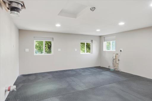 Expansive upper-level studio is currently used as a home gym and features recessed lighting, and multiple windows for abundant natural light. The flexible open layout can easily adapt to a fitness room, art studio, or countless other uses.