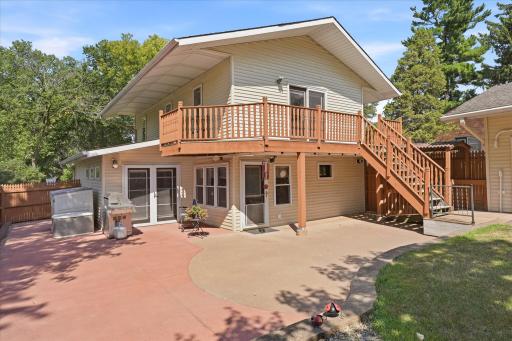 The backyard is designed for entertaining with a spacious stamped concrete patio, direct walkout access from the home, and an impressive upper-level deck overlooking the private, fenced yard.