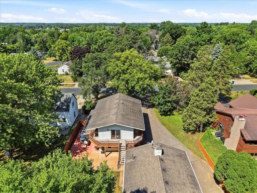 Aerial perspective captures the home's incredible outdoor living spaces, including the expansive upper-level deck, spacious patio, detached studio building, and beautifully landscaped yard.