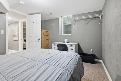 Bedroom 8 in lower level with dresser, desk and Egress window.jpg