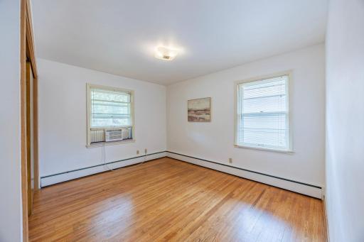 The first main floor bedroom boasts abundant natural light and pristine hardwood floors.