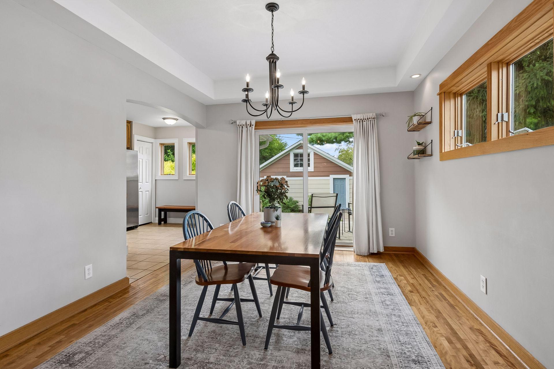 Dining room with sliding door opening up to the deck and fenced backyard.