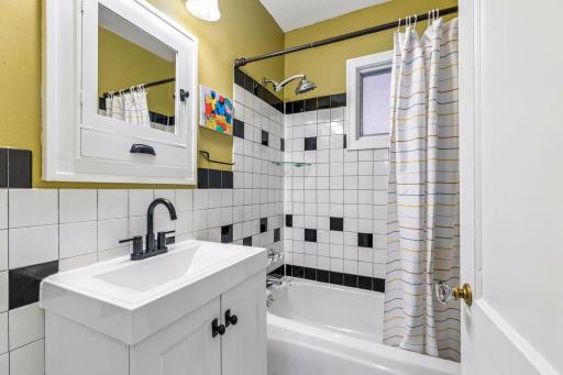 Main floor full bathroom featuring black and white tile.
